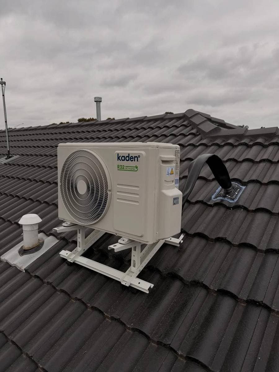 Kaden outdoor condenser mounted on a bracket outside a home