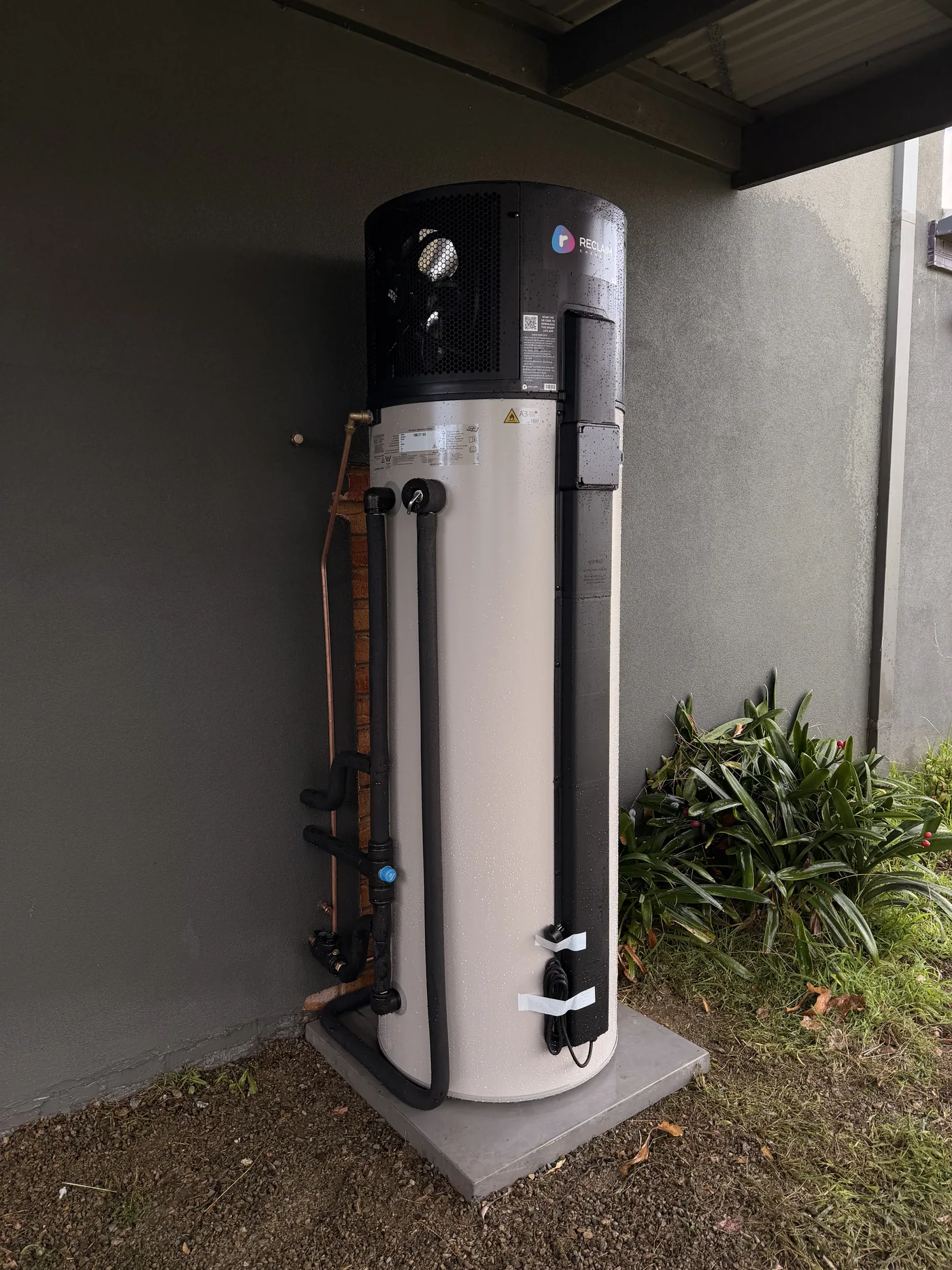 New Reclaim heat pump hot water system on a fresh concrete pad in the same position
