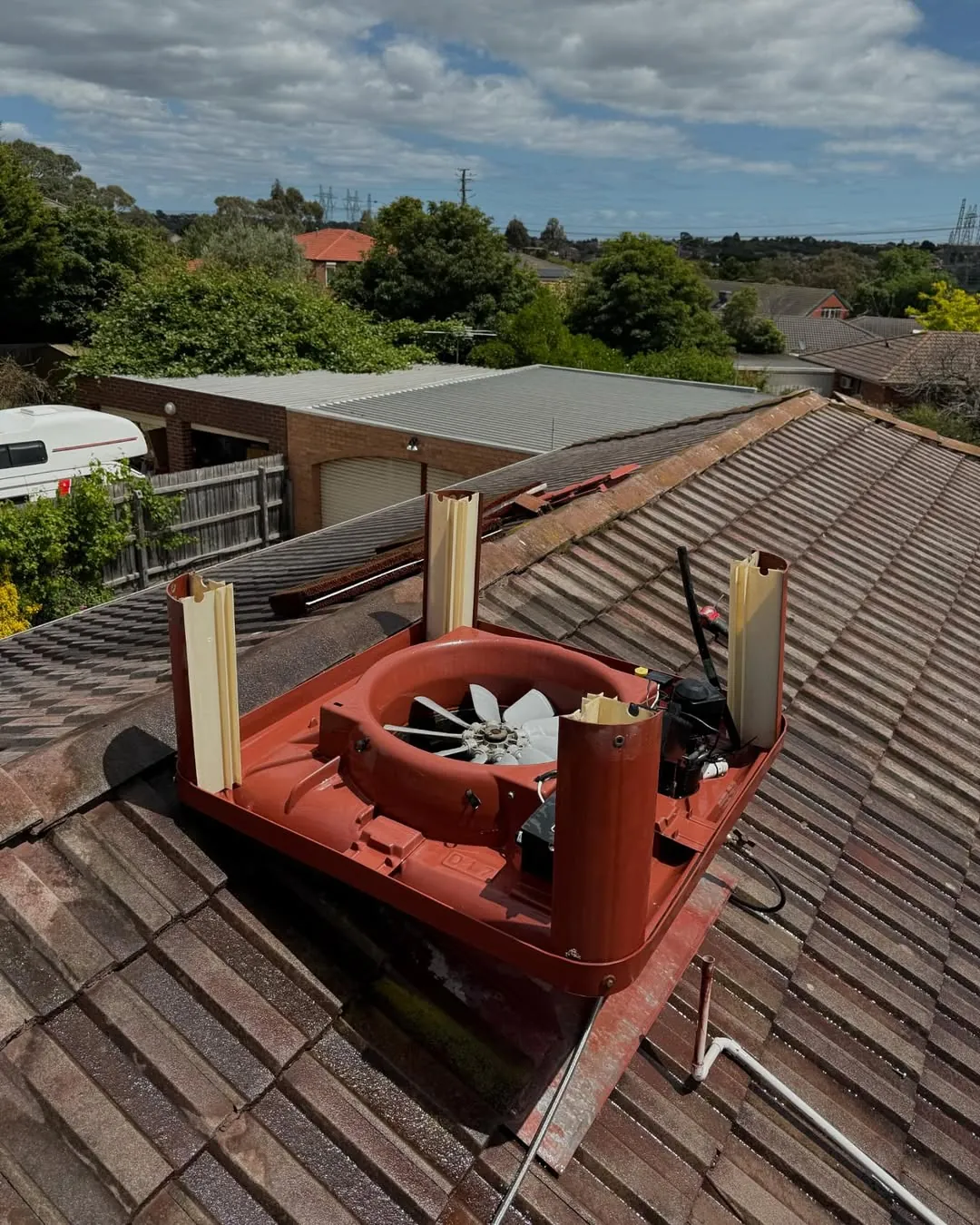 Roof-mounted evaporative cooler being serviced