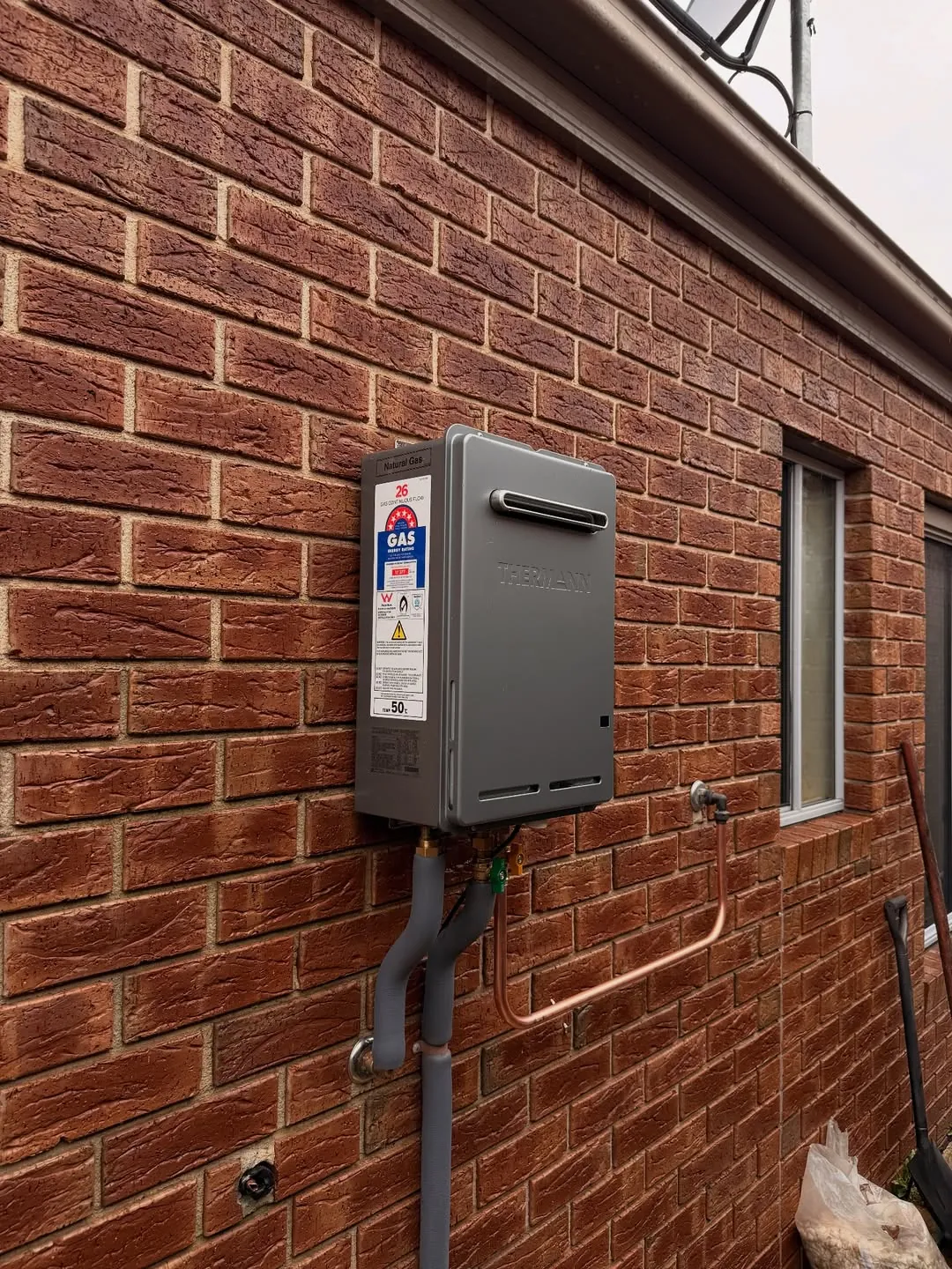 Thermann continuous flow gas hot water unit mounted on an external wall