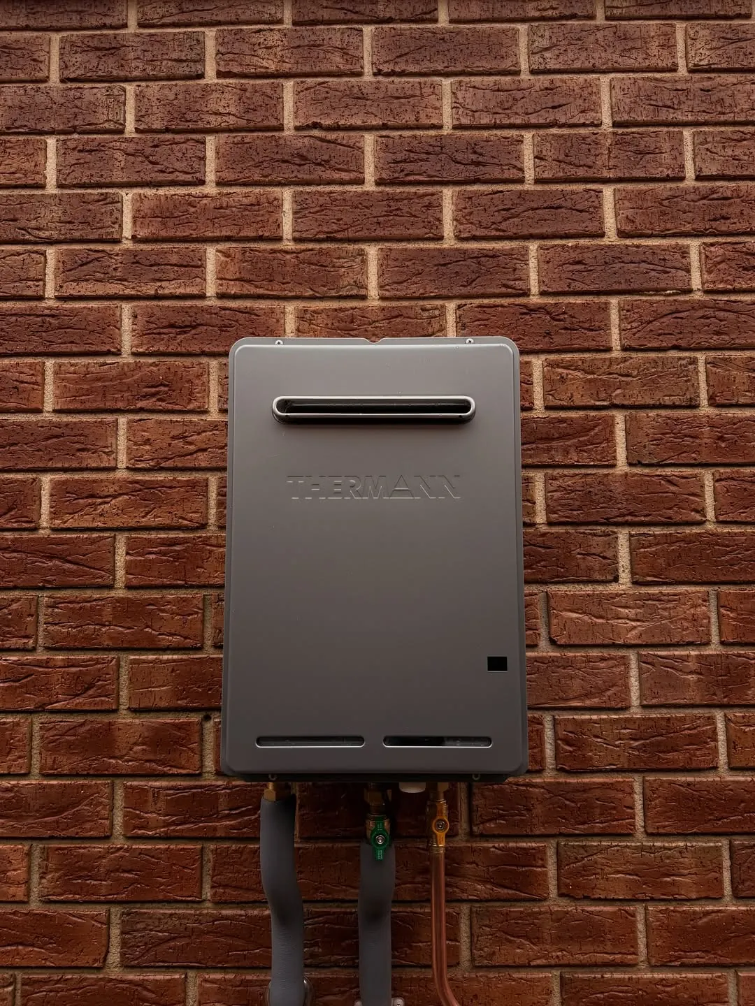 Close up of Thermann continuous flow gas hot water pipework